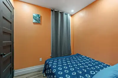 a bedroom with orange walls and a bed and a window at Spacious Home In Troy in Troy