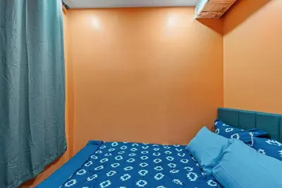 a bed with blue pillows and an orange wall at Spacious Home In Troy in Troy
