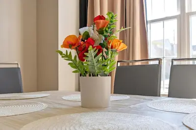 a vase filled with flowers sitting on top of a table at Spacious Home In Troy in Troy