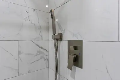a shower in a bathroom with white marble walls at Spacious Home In Troy in Troy