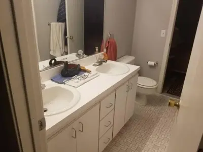 a bathroom with two sinks and a mirror and a toilet at Farmington Guest Housing in Farmington