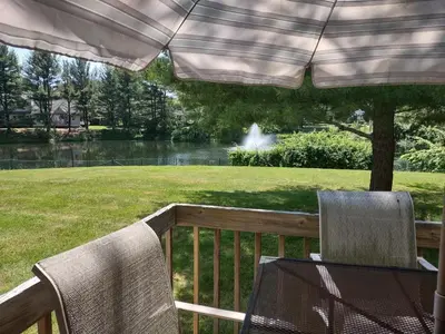 a table and two chairs on a deck with an umbrella at Farmington Guest Housing in Farmington