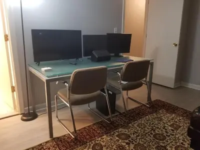 a desk with two monitors and three chairs at Farmington Guest Housing in Farmington