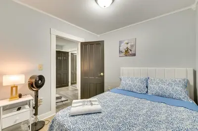 a bedroom with a bed with a blue comforter at Walk to Local Eats! Updated Schenectady Apartment in Schenectady