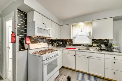 a kitchen with white cabinets and a stove top oven at Walk to Local Eats! Updated Schenectady Apartment in Schenectady
