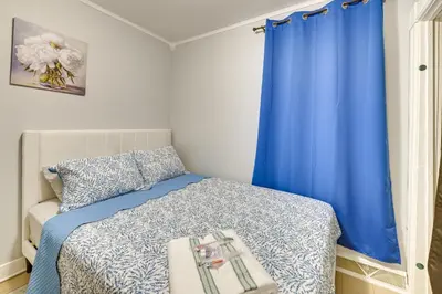 a bedroom with a bed with a blue curtain at Walk to Local Eats! Updated Schenectady Apartment in Schenectady