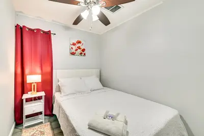 a bedroom with a bed with a red curtain at 2 Mi to Union College! Newly Renovated Apartment in Schenectady