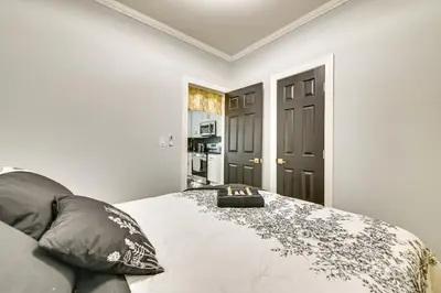 a bedroom with a bed with a black door at Walk to Park Modern Apt 2 Mi to Union College! in Schenectady