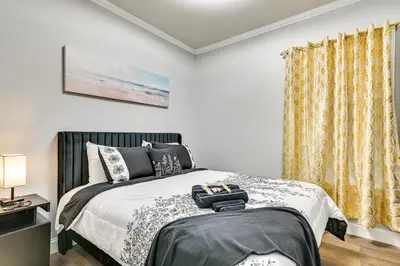 a bedroom with a bed and yellow curtains at Walk to Park Modern Apt 2 Mi to Union College! in Schenectady