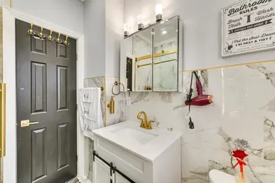 a white bathroom with a sink and a mirror at Walk to Park Modern Apt 2 Mi to Union College! in Schenectady