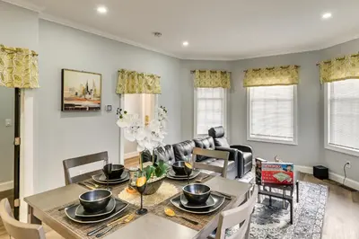 a dining room and living room with a table and chairs at 2 Mi to Downtown Charming Apt in Schenectady! in Schenectady