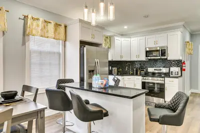 a kitchen with white cabinets and a table and chairs at 2 Mi to Downtown Charming Apt in Schenectady! in Schenectady