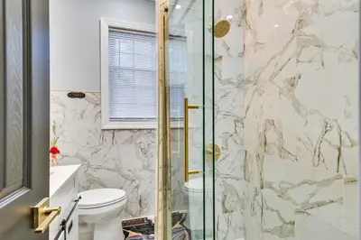 a bathroom with a toilet and a glass shower at 2 Mi to Downtown Charming Apt in Schenectady! in Schenectady