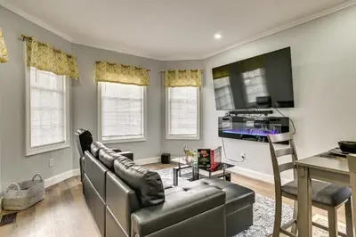 a living room with a couch and a tv and a table at 2 Mi to Downtown Charming Apt in Schenectady! in Schenectady