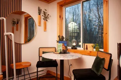 a small table and chairs in a room with a window at The A-Frame on Pudding Hill in Stamford