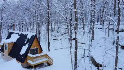 a cabin in the woods covered in snow at The A-Frame on Pudding Hill in Stamford