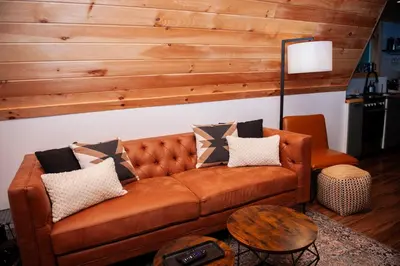 a brown couch with pillows on it in a living room at The A-Frame on Pudding Hill in Stamford