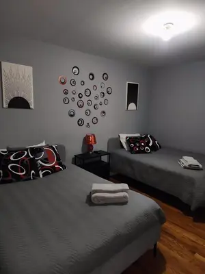 a bedroom with two beds and a clock on the wall at 2 Beds - Work & Study - NYC - EWR - Walk to Train in East Newark