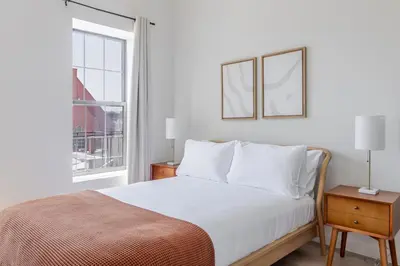a white bedroom with a bed and a window at Blueground Greenpoint view nr Transmitter Park NYC-1896 in Brooklyn