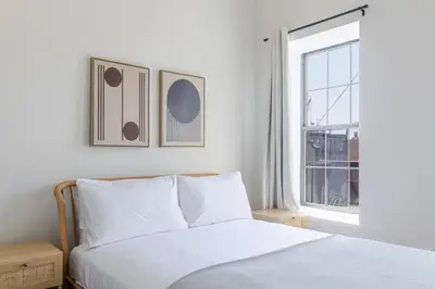 a bedroom with a white bed and a window at Blueground Greenpoint view nr Transmitter Park NYC-1896 in Brooklyn