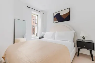 a white bedroom with a white bed and a window at Blueground Midtown East view nr UN Plaza NYC-2126 in New York
