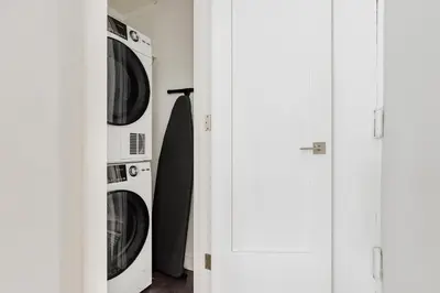 two washer and dryer in a room with doors at Blueground Midtown East view nr UN Plaza NYC-2126 in New York