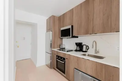 a kitchen with wooden cabinets and a sink at Blueground Midtown East view nr UN Plaza NYC-2126 in New York