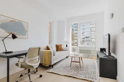 a white living room with a white couch and a desk at Blueground Downtown Brooklyn rooftop nr Brooklyn Bridge NYC-2125 in Brooklyn
