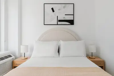 a bedroom with a white bed with two lamps at Blueground Downtown Brooklyn rooftop nr Brooklyn Bridge NYC-2125 in Brooklyn