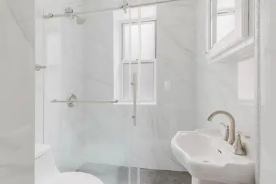 a white bathroom with a sink and a shower at Blueground Alphabet City washer nr Tompkins Square Park NYC-2160 in New York