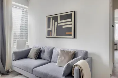 a grey couch in a living room with a picture on the wall at Blueground Midtown South rooftop nr Bryant Park NYC-2031 in New York