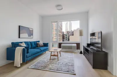 a living room with a blue couch and a window at Blueground Long Island City fitness center nr Gantry Plaza State Park NYC-2181 in New York