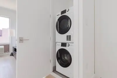 two washing machines in a wall in a room at Blueground Long Island City fitness center nr Gantry Plaza State Park NYC-2181 in New York