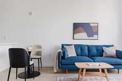 a living room with a blue couch and a table at Blueground Long Island City fitness center nr Gantry Plaza State Park NYC-2181 in New York