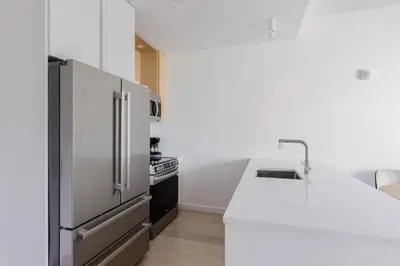 a kitchen with a stainless steel refrigerator and a stove at Blueground Long Island City fitness center nr Gantry Plaza State Park NYC-2181 in New York
