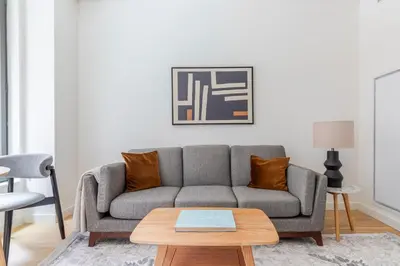 a living room with a gray couch and a table at Blueground Chelsea rooftop pool nr The Vessel NYC-2147 in New York