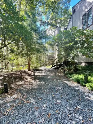 a gravel path next to a building with trees at Lake Naomi Retreat Family Fun & Games in Pocono Pines