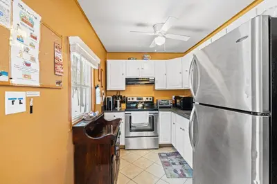 a kitchen with white cabinets and a stainless steel refrigerator at Hot Tub + Fire Pit • Game Room • Community Pool in Tobyhanna