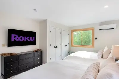 a bedroom with two white beds and a tv on a wall at 5 Minutes to Ski Hunter Mountain! Family Friendly - Hot Tub, Sauna, Sunset Views in Hunter