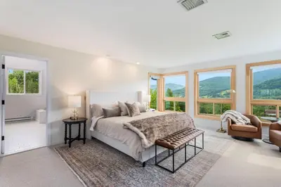 a bedroom with a bed and a couch and windows at 5 Minutes to Ski Hunter Mountain! Family Friendly - Hot Tub, Sauna, Sunset Views in Hunter