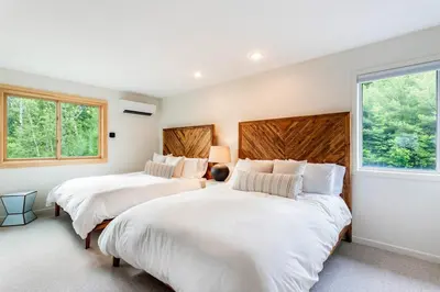 two beds in a room with two windows at 5 Minutes to Ski Hunter Mountain! Family Friendly - Hot Tub, Sauna, Sunset Views in Hunter
