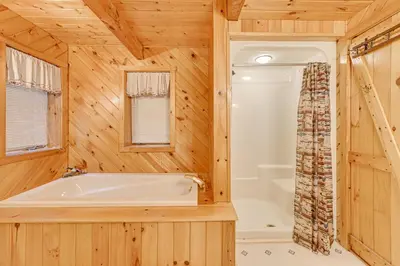 a wooden bathroom with a tub and a shower at On-Site Pond and Trails Lake Luzerne Cabin in Lake Luzerne