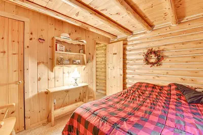 a bedroom with a bed in a wooden cabin at On-Site Pond and Trails Lake Luzerne Cabin in Lake Luzerne