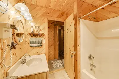 a bathroom with a shower and a sink and a tub at On-Site Pond and Trails Lake Luzerne Cabin in Lake Luzerne