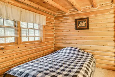 a bedroom with a bed in a log cabin at On-Site Pond and Trails Lake Luzerne Cabin in Lake Luzerne