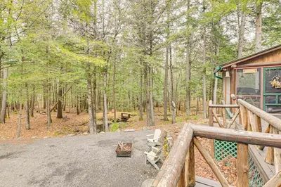 a porch of a cabin in the woods at On-Site Pond and Trails Lake Luzerne Cabin in Lake Luzerne