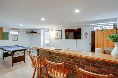 a kitchen with a bar with a ping pong table at 5 Mi to Mt Snow Secluded Family Home with Game Area in West Dover
