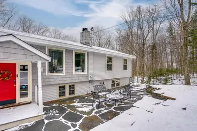 a white house with a red door and a patio at 5 Mi to Mt Snow Secluded Family Home with Game Area in West Dover