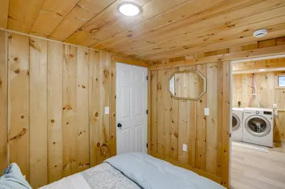 a bedroom with a bed and a washing machine at 5 Mi to Mt Snow Secluded Family Home with Game Area in West Dover