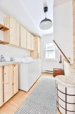 a kitchen with wooden cabinets and a rug at Cozy Winter Retreat Minutes from Hunter Mountain in Jewett